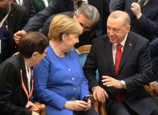 Turkish President Recep Tayyip Erdogan speaks with German Chancellor Angela Merkel, during the Turkish-German University's new facilities opening ceremony in Istanbul