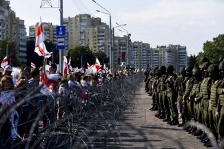 Zdjęcie protestujących stojących naprzeciwko sił służb