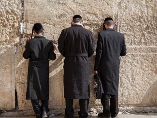 The picture shows three praying Jews.